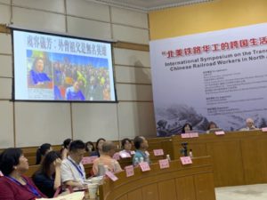 Connie Young Yu presenting her paper on the oral histories of Chinese railroad workers that she collected. On the screen is a video clip of her speech at the opening of the 150th Anniversary of the Golden Spike commemorations in Utah on May 10, 2019.